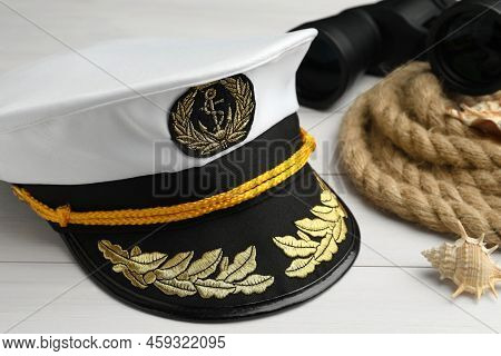 Peaked Cap, Rope, Shells And Binoculars On White Wooden Background, Closeup