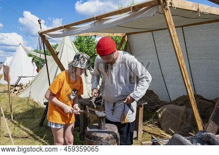 Tver Region, Russia - July 22, 2022: A Blacksmith Shows A Teenage Girl The Basics Of An Ancient Blac