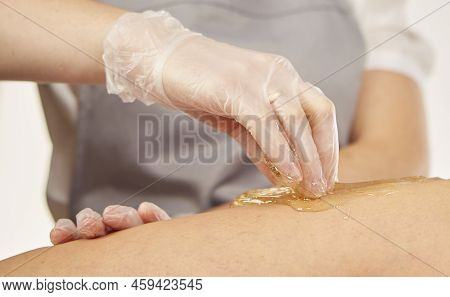 Sugar Paste For Light Depilation. Depilation With Sugar Paste In The Salon On A White Background.