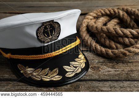 Peaked Cap With Accessories And Rope On Wooden Background, Closeup