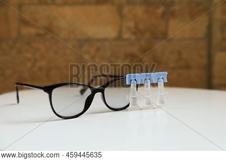 Single Dose Eye Drops And Glasses On White Table