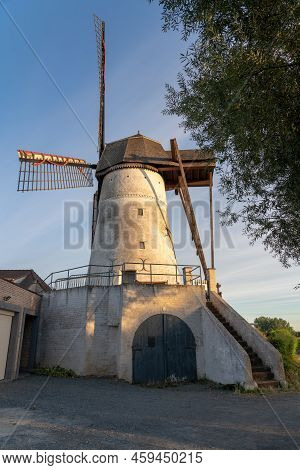 Early In The Morning There Is A Beautiful Windmill Whit The Sun Rising In The Sky