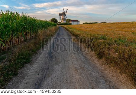 Early In The Morning There Is A Beautiful Windmill Whit The Sun Rising In The Sky