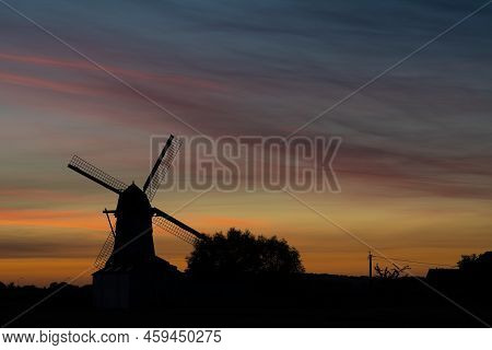 Early In The Morning There Is A Beautiful Windmill Whit The Sun Rising In The Sky