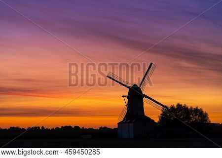 Early In The Morning There Is A Beautiful Windmill Whit The Sun Rising In The Sky