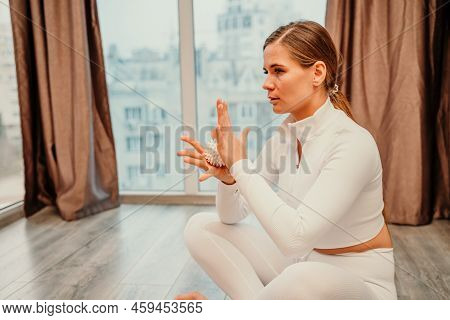 Athletic Slim Caucasian Woman Doing Thigh Self-massage With A Massage Ball Indoors. Self-isolating M