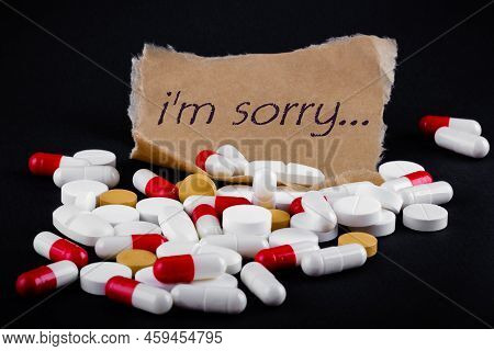 Text I'm Sorry On A Piece Of Paper Next To A Pile Of Pills. Death Note. Suicide Concept.
