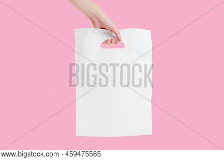 Plain White Shopping Bag In Hand Isolated On Pink Background. Boutique Packaging.