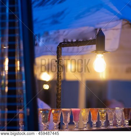 Glass Stacks Are Filled With Different Drinks As An Advertisement In A Drinking Establishment, A Bar