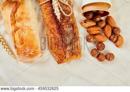 Top View Of Two Baguettebread And Nuts On A Textile Surface.