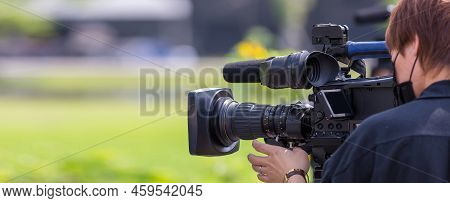 Video Camera Operator Working With His Equipment. Video Cinema Production. Covering An Event With A 