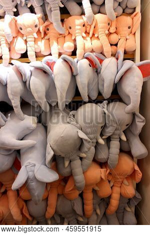 Stuffed Animals Arranged In A Shelf For Sale. Grey And Peach Colored Elephants Stuffed In A Shelf. C