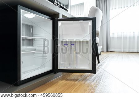 Black Mini Small Fridge Refrigerator Under The Frame Wooden Counter In Hotel Resort Bedroom