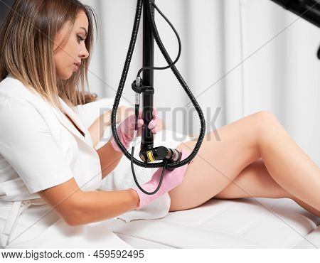 Cosmetologist In Sterile Gloves Using Erbium Ablative Laser Machine While Performing Laser Treatment