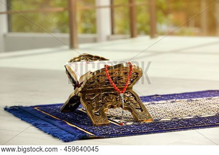 Rehal With Open Quran And Misbaha On Muslim Prayer Rug Indoors