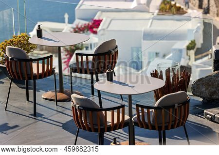 Tables On The Restaurant Terrace With A Picturesque View Of The Sunset In Imerovigli. Santorini, Gre