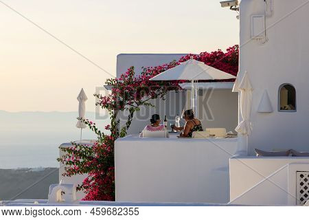 Imerovigli, Santorini, Greece - June 29, 2021: Red Bougainvillea Climbing On The Wall Of Whitewashed