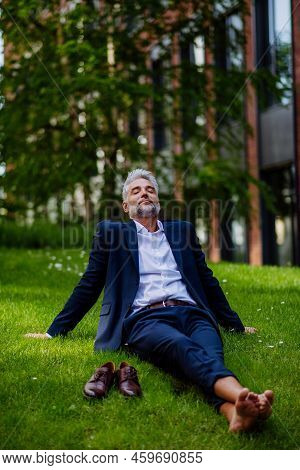 Mature Businessman Resting And Sitting Barefoot In Park, Feeling Free, Escaping From Work, Work Life