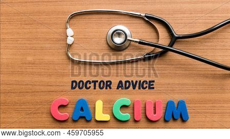 Different Color Word Of Calcium And Black Color In Doctor Advice With Doctor Stethoscope On Wooden T