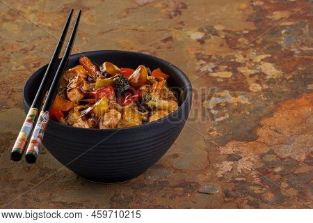Chicken Yakissoba In Black Ceramic Bowl On Rusty Slate
