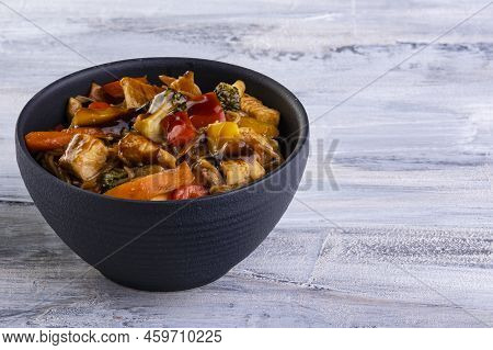 Chicken Yakissoba In Black Ceramic Bowl On Light Background