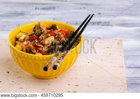 Chicken Yakisoba In Yellow Bowl Over Travertine Marble Stone