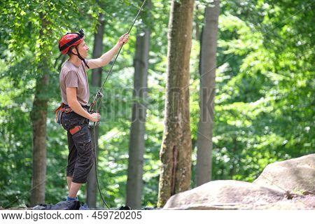 Man Belays His Partner Climber With Belaying Device And Rope. Climbers Handsman Holding Equipment Fo