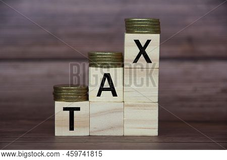 Tax Word On Wooden Blocks With Gold Coins On Top. Tax Concept.