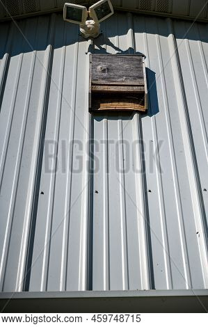 Wooden Bat House On White Corrugated Tin Barn