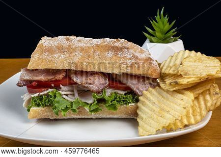 Tukey Meat With A Blt On Ciabatta Bread And A Side Of Potato Chips