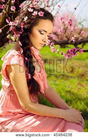 Bajki młoda kobieta siedzi w ogrodzie blossomy