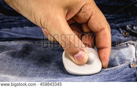 Hand Removing Anti-theft Device Used In Commerce, Tag Or Anti-theft Tag On Denim Clothing, Attempted