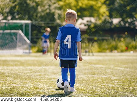 Football Player Running Ball Background. Low Angle Image Of Soccer Boy Kicking Ball On Grass Trainin