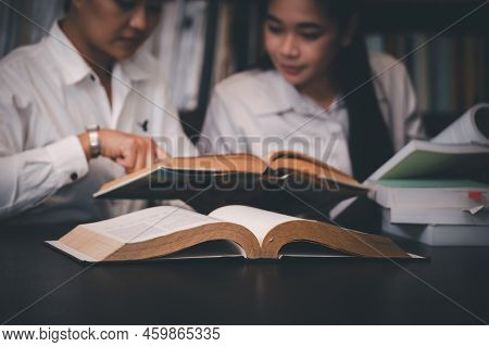 Group Of Diversity Student Study And Reading Book Together In Library At Asian College. Happy Multi 