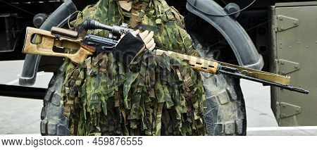 Close-up Portrait Of A Military Sniper In Camouflage Green Army Clothes With A Degtyarev Sniper Rifl