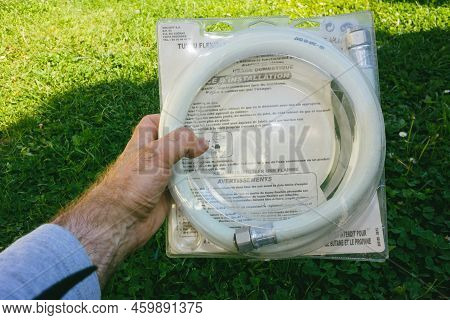 Paris, France - May 9, 2022: Pov Male Hand Holding White Flex Tube For Gas Connection
