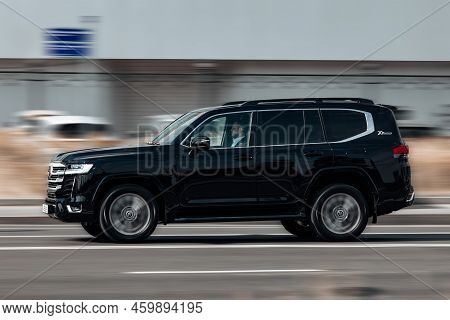 Toyota Land Cruiser 300 Rides On The City Highway. Black Premium Suv On The City Street In Motion. M