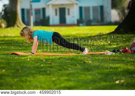 Sport Kids. Child Is Pushing Up On The Green Grass. Boy Doing Push-ups In The Yard. Kid Pushing Up.