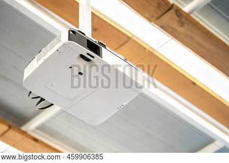 White Projector Hang It On The Ceiling In The Middle Of The Meeting Room.