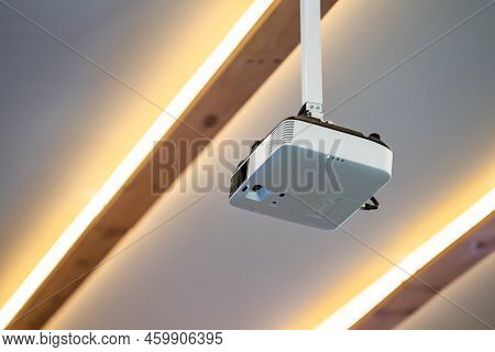 White Projector Hang It On The Ceiling In The Middle Of The Meeting Room.