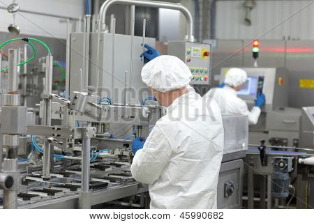 dos trabajadores de uniformes en la línea de producción en planta