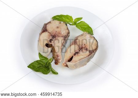 Baked Pieces Of The Japanese Amberjack Or Yellowtail And Twigs Of The Fresh Basil On A White Dish On