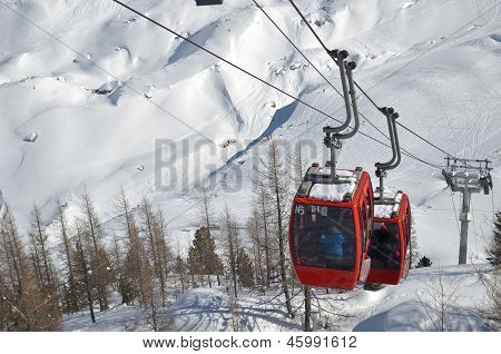 Cablecars bevæger sig op sne dækket bjerg
