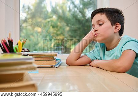 Portrait Of An Overworked, Sleepy Caucasian Teenager, A Schoolboy Feeling Himself Tired While Doing 