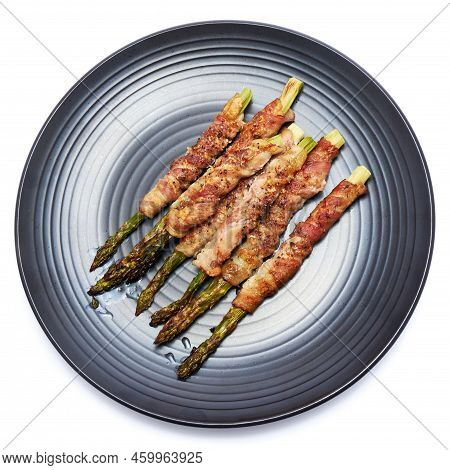 Baked Aspargus Covered With Bacon On Ceramic Plate Isolated On White Background