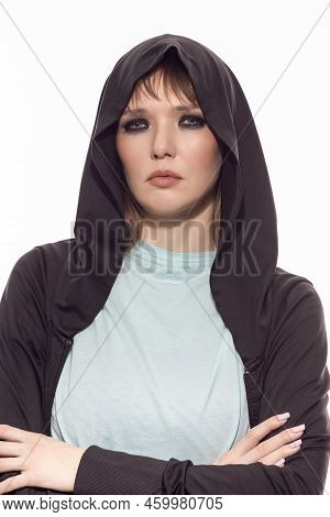 Closeup Portrait Of Blond Caucasian Female Athlete In Black Hoody Posing With Folded Hands While Loo