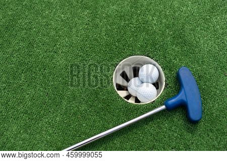 Close-up Of Miniature Golf Hole With Bat And Ball