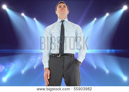 Serious businessman standing with hand in pocket against cool nightlife lights
