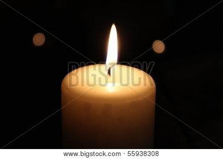 Lighted candle on a black background