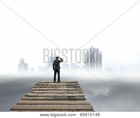 Businessman Gazing At City With Cloudy Under